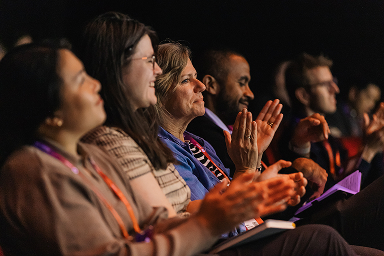 Audience members applauding a UXDX session